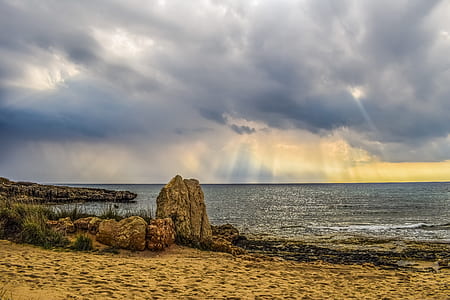 rock formation beside body of water thumbnail