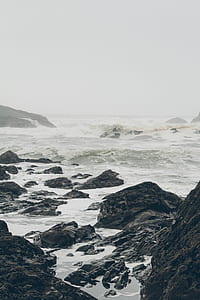 photo of sea waves beside rocks during daytime thumbnail