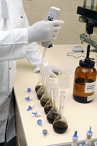 scientist holding dropper filling laboratory flasks thumbnail