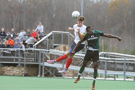 two men playing soccer on field thumbnail