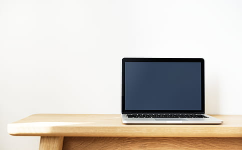 laptop on brown wooden table thumbnail