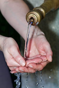 person washing hands on faucet thumbnail