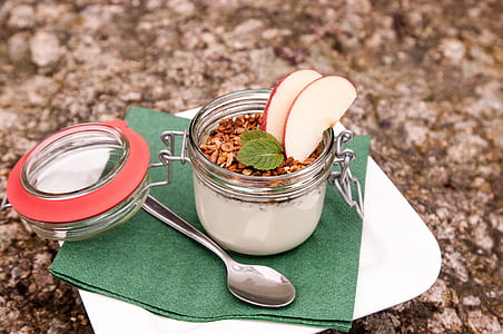 cereal with milk and apple slice in clear glass canister thumbnail