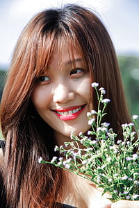 woman with brown hair and holding flowers thumbnail
