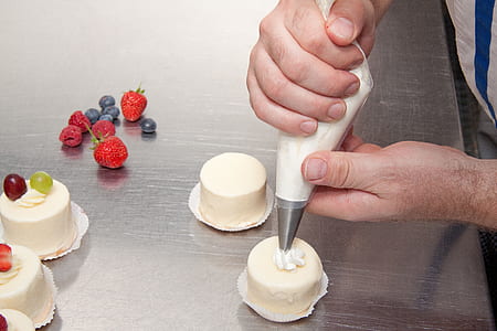 person putting icing on mini cake thumbnail