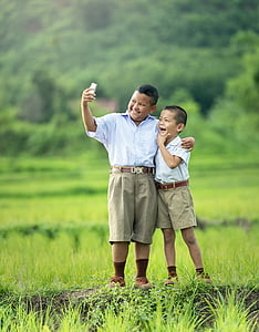 two boys wearing school uniform in the middle of field thumbnail