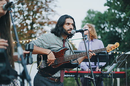 singing man using guitar in front of microphone thumbnail