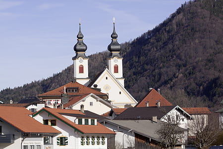 white and brown concrete building beside mountain thumbnail