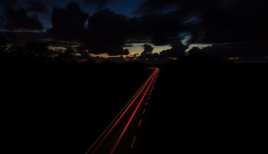 red and gray roadway between trees thumbnail