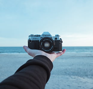 person holding gray Canon camera thumbnail