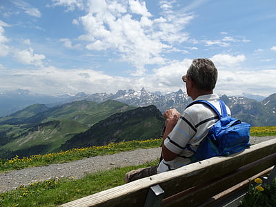 man leaning on gray fence under cloudy sky thumbnail
