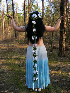 woman in blue and white skirt standing near trees during daytime thumbnail