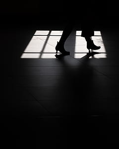 silhouette of woman walking through light from window thumbnail