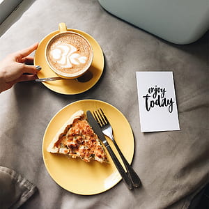 flat lay photography of slice of pizza and cappuccino with latte art thumbnail