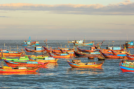 orange boats on body of water during golden hour thumbnail