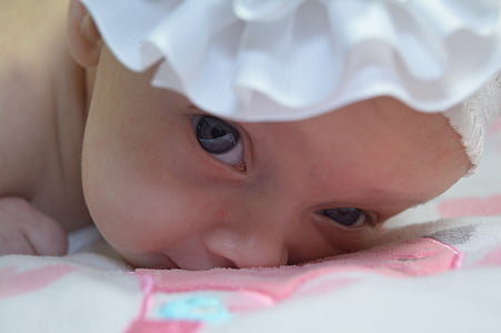 close-up photo of baby in white headband thumbnail