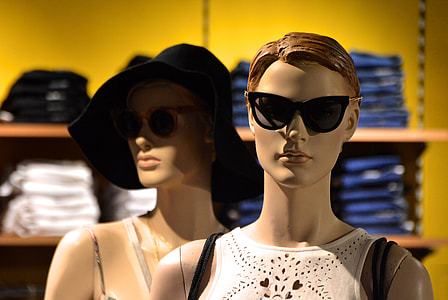 selective focus photo of two mannequins in white tops and sunglasses thumbnail