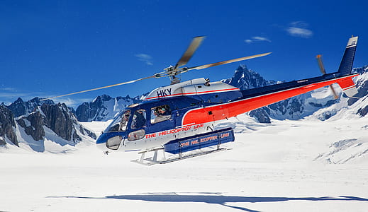 blue and orange helicopter on snow-covered field thumbnail