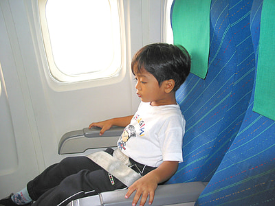boy sitting on plane seat with belt on thumbnail