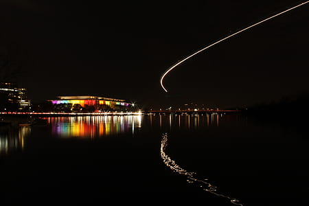 asymmetrical photography of assorted-color of lighted buildings near body of water thumbnail