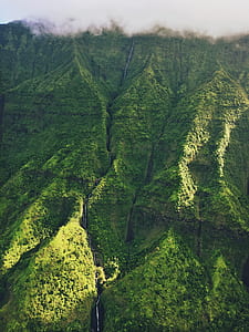 aerial photography of green mountain under foggy sky during daytime thumbnail