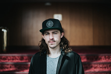 man wearing black cap and black zip-up jacket thumbnail