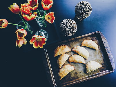 red-and-yellow tulip flowers beside pan of empanada thumbnail