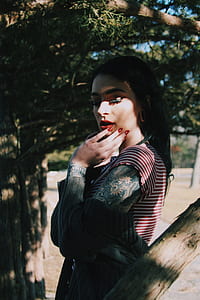 woman standing beside brown tree thumbnail