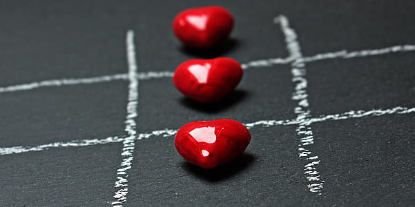 close up photo of three heart-shaped red stones thumbnail