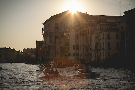photo of powerboats on water near white painted multi-storey building thumbnail