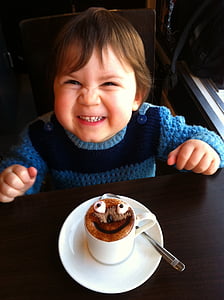 boy wearing blue sweater sitting in front of table thumbnail