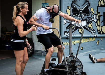 woman guiding man on fan bike wearing gas mask thumbnail