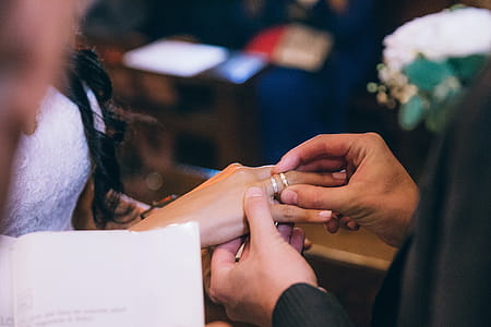 Groom putting wedding ring on the bride s finger in church thumbnail