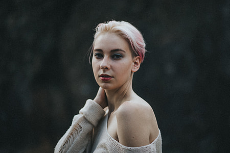 woman wearing beige sweater holding her neck thumbnail