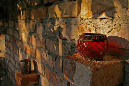 two red pomegranate glass vases placed on beige bricks thumbnail