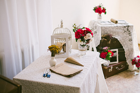 white metal cage on table near flowers thumbnail