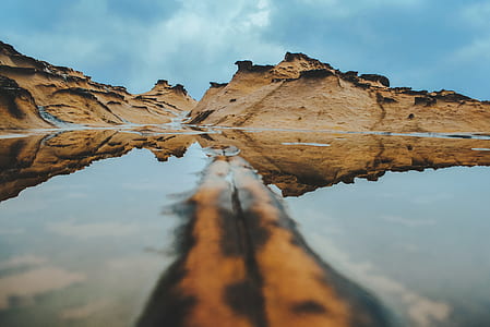 brown mountains beside body of water thumbnail