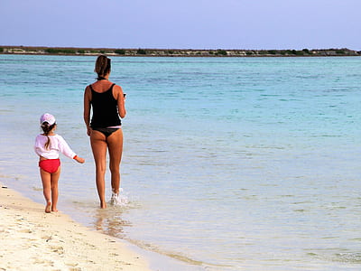 woman and girl walking on seashore thumbnail