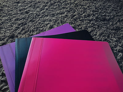 three assorted-color plastic folders on gray fleece textile thumbnail