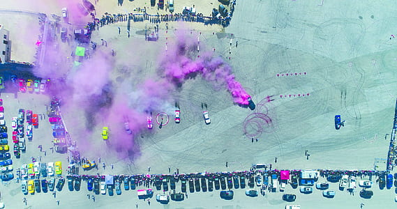 pink smoke bomb with vehicle lot during daytime thumbnail