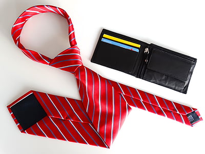 red and grey striped necktie beside black leather wallet on white surface thumbnail