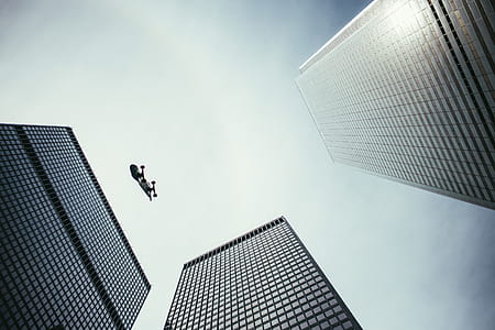 Pesrpective view of skateboard in the air with skyscrapers thumbnail
