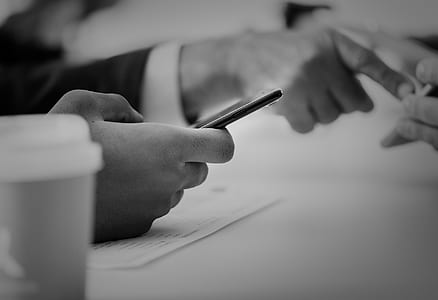 grayscale photography of person using smartphone thumbnail