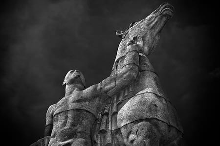 low angle photography of person standing beside horse statue thumbnail