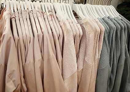 beige and gray hanging tops with hangers on rack thumbnail