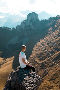 photo of man sitting on boulder thumbnail