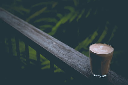 filled clear drinking glass on brown rack thumbnail
