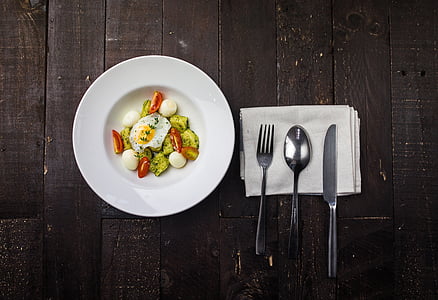 egg and vegetable on plate beside cutlery on table thumbnail