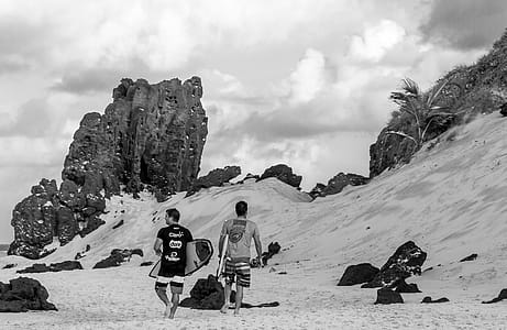 Grayscale Photo of Two Men Carrying Surfboards thumbnail