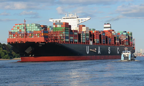 red and black UASC cargo ship on body of water thumbnail